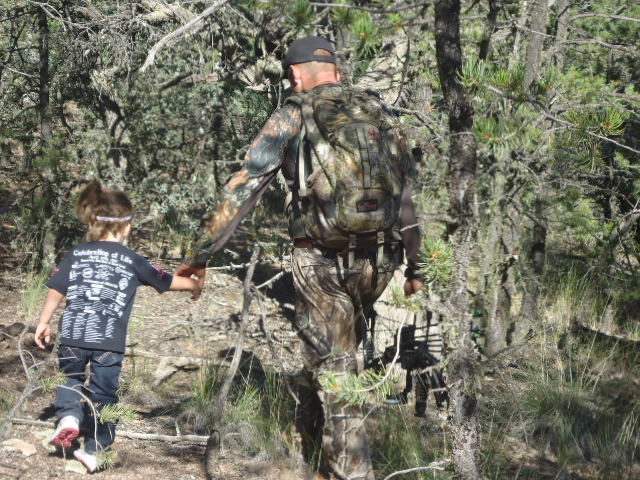 Father and child walking in a forest near the Gila River